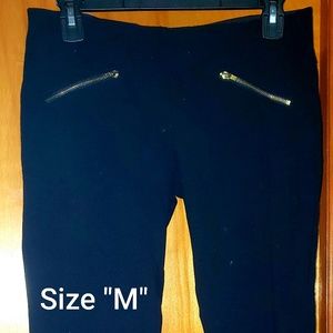 Black, fitted casual pants with gold front zippers